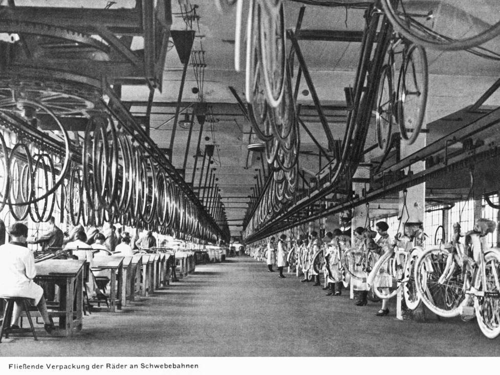 Fahrrad-Bau in der Opel-Fabrikhalle: Schwebebahnen transportieren einzelne Räder und fertige Modelle