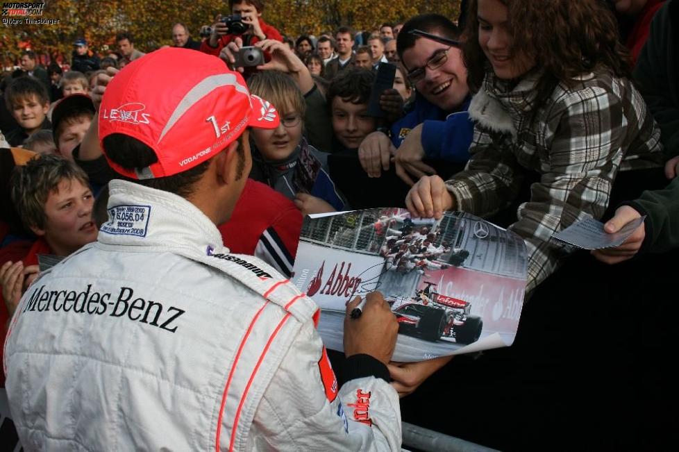 Lewis Hamilton schreibt Autogramme