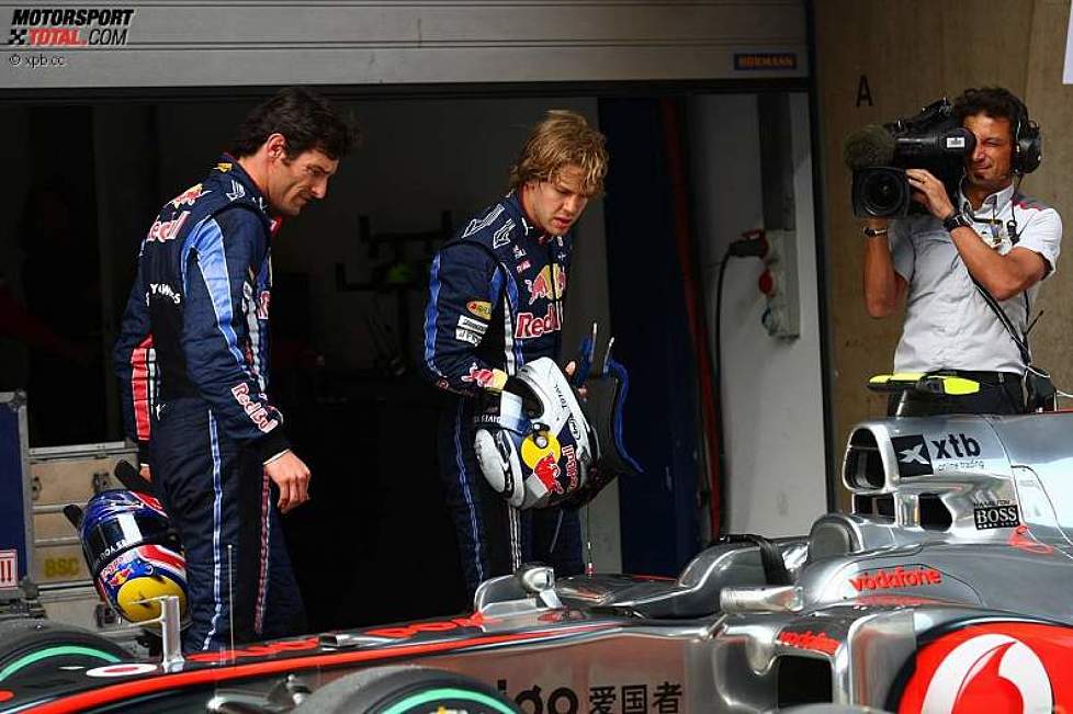 Mark Webber (Red Bull) und Sebastian Vettel (Red Bull) betrachten den McLaren