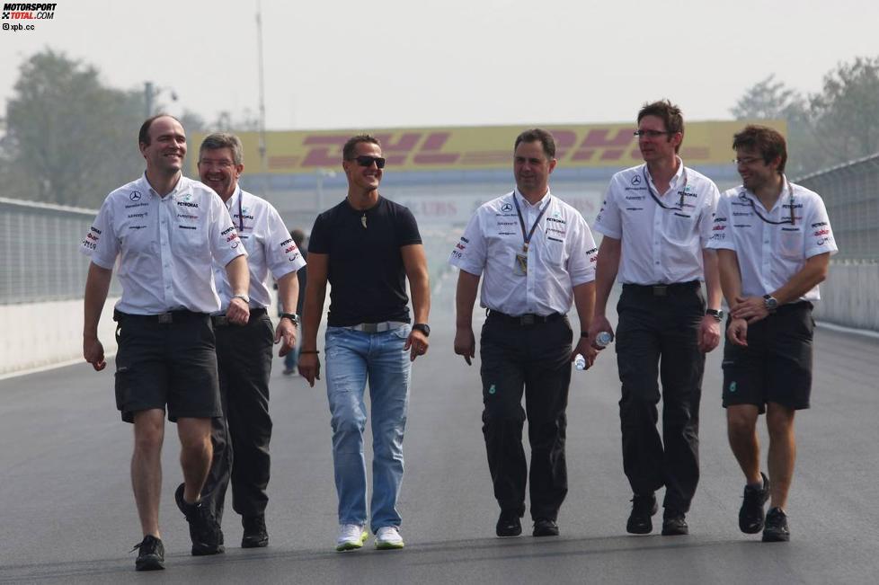 Ross Brawn (Teamchef), Michael Schumacher (Mercedes) und Andrew Shovlin (Renningenieur) gehen die Strecke ab