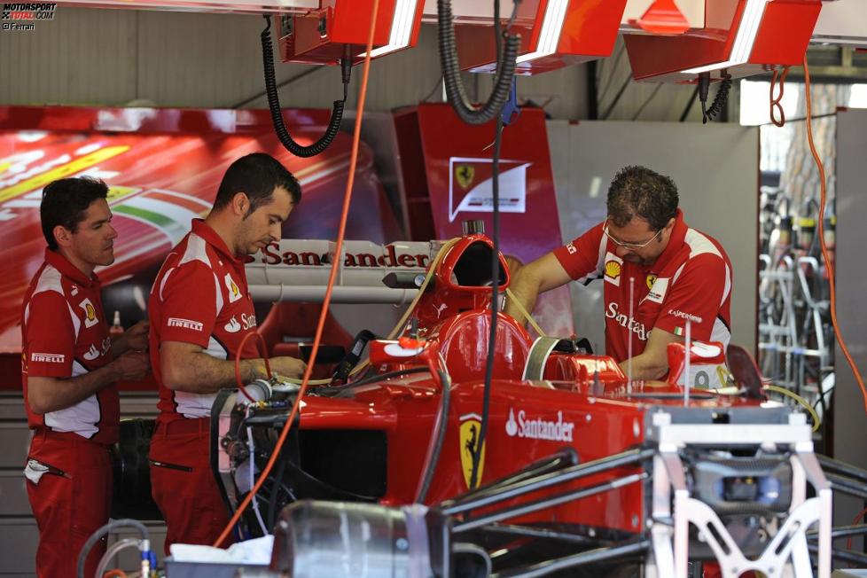 Ferrari-Mechaniker bereiten das Auto auf das Wochenende vor