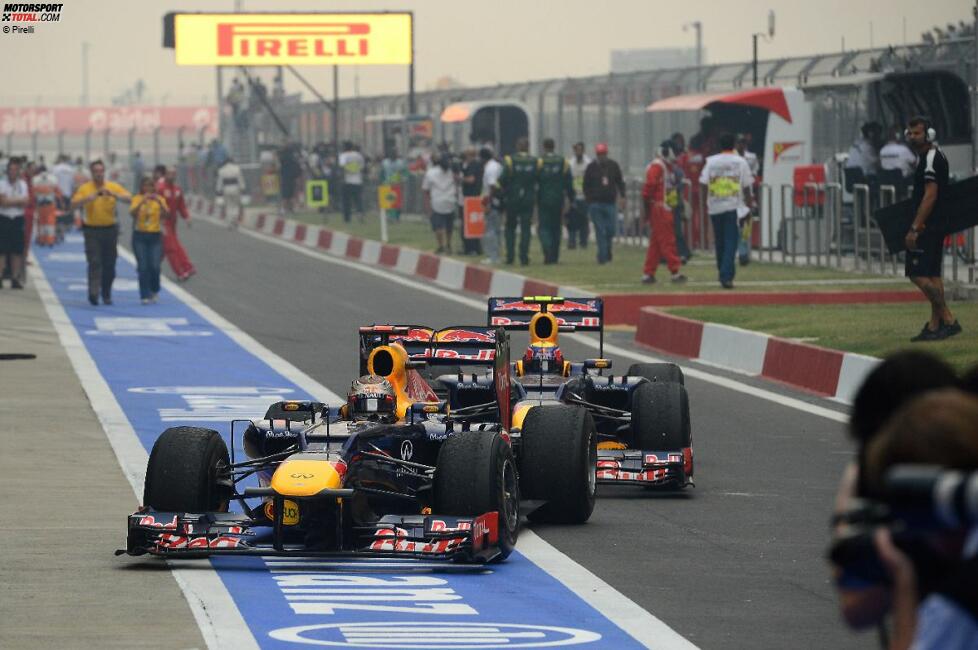 Sebastian Vettel (Red Bull) wird von Mark Webber (Red Bull) auf seine Position im Parc ferme geschoben