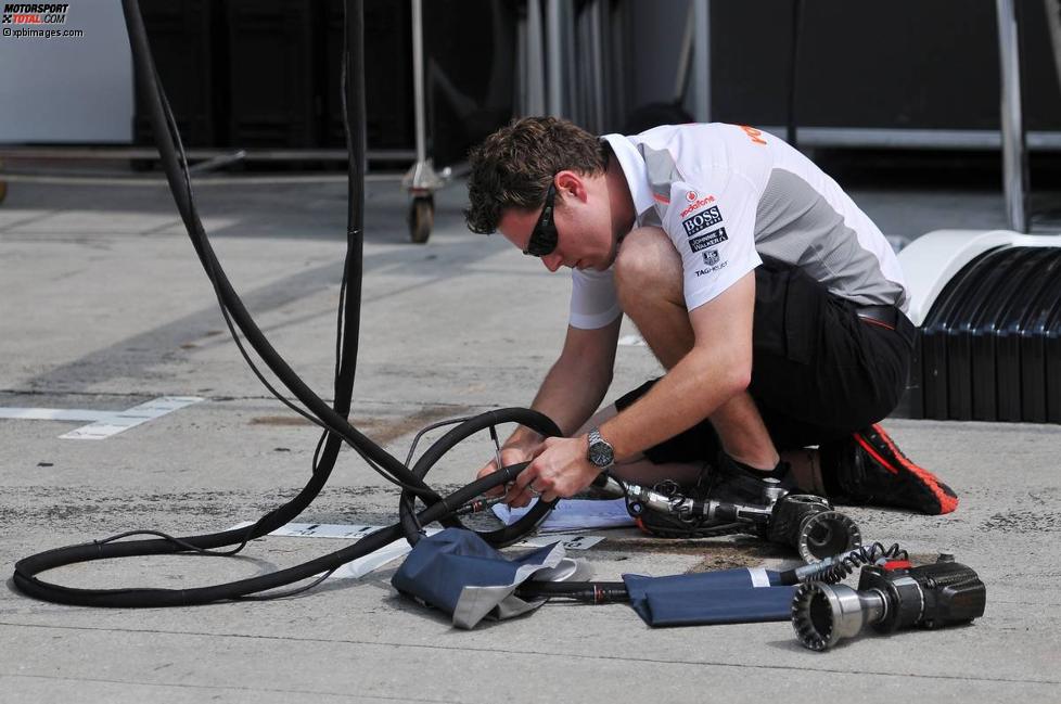 McLaren-Mechaniker entwirrt die Schlagschrauber-Schläuche