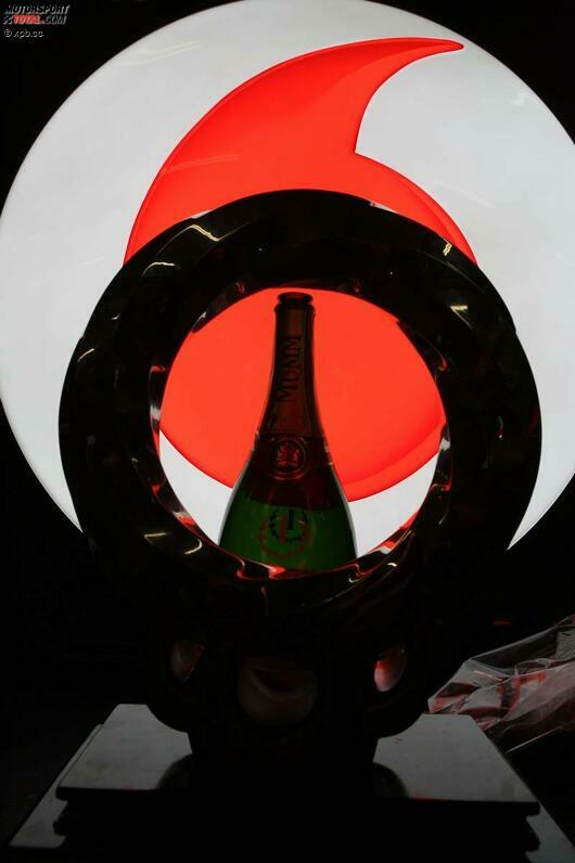 Siegerpokal und Champagner im Dunkeln, das Logo von Hauptsponsor Vodafone strahlend hell. Die PR-Maschinerie der Formel 1 ist bis ins kleinste Detail durchgestylt.