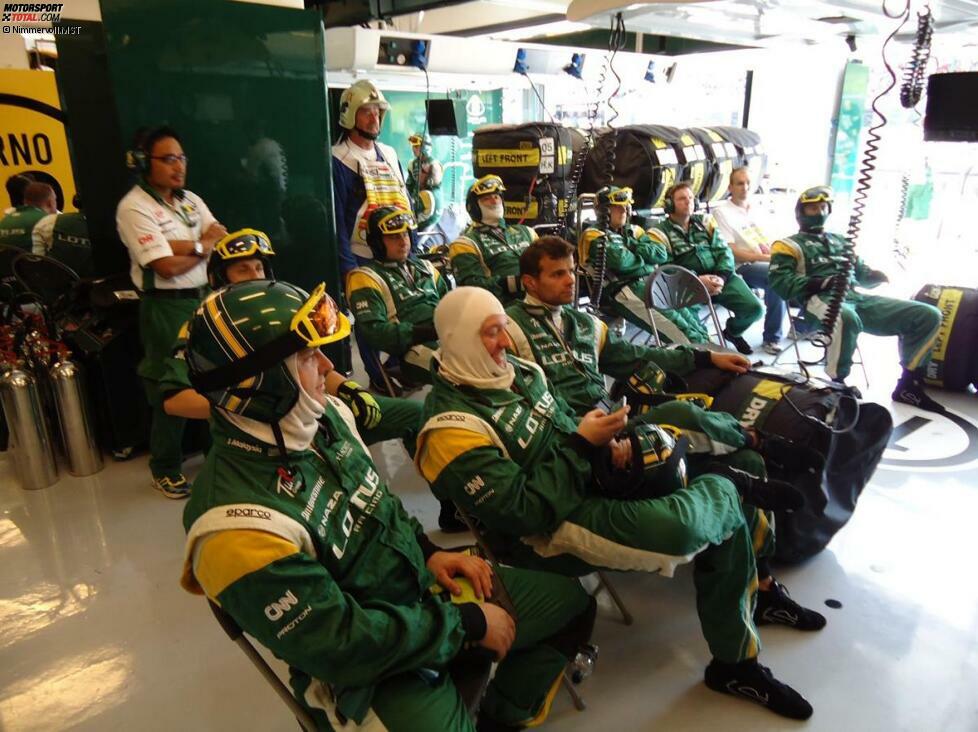 Start des Rennens: Die Mechaniker sitzen in der Box ihres Fahrers und stehen auf Abruf bereit, sollte etwas Unvorhergesehenes passieren. Nur ein paar von ihnen nehmen dabei den Helm ab - wegen der Hitze.