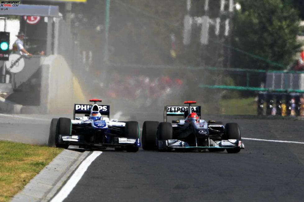 Doch selbst im Nachgeben fuhr Schumacher noch weit auf der rechten Seite, dass Barrichello fast noch über das Gras ausweichen muss.