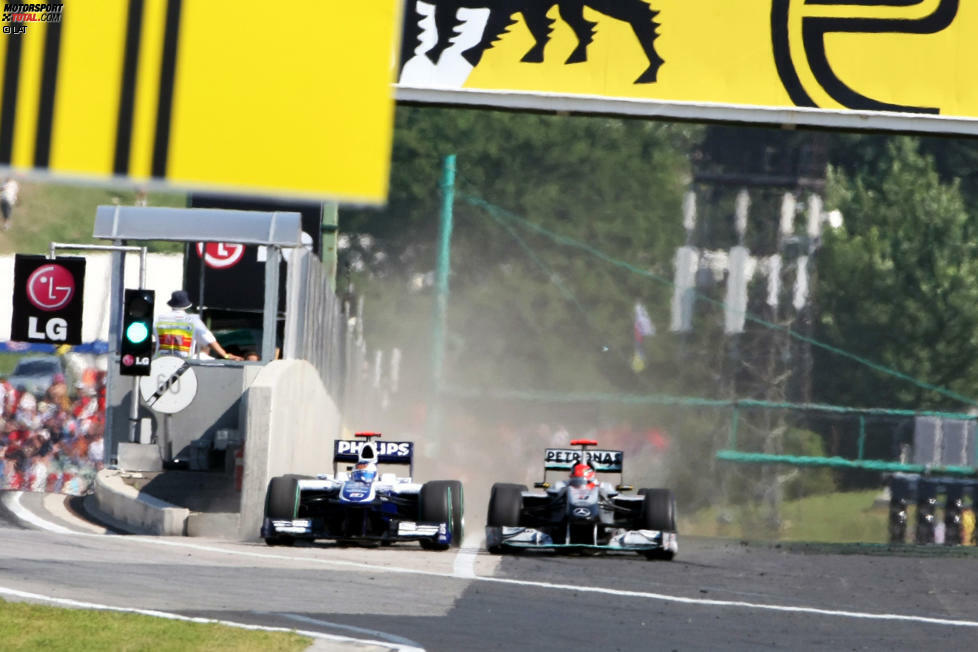 Der Williams von Barrichello zwängt sich bei mehr als 250 km/h durch die enge Lücke zwischen Boxenmauer und Schumachers Mercedes.