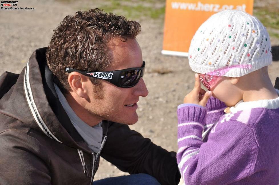 Timo Scheider mit der krebskranken Amelie, einem der vielen Kinder, das vom Verein Stunde des Herzens unterstützt wird.