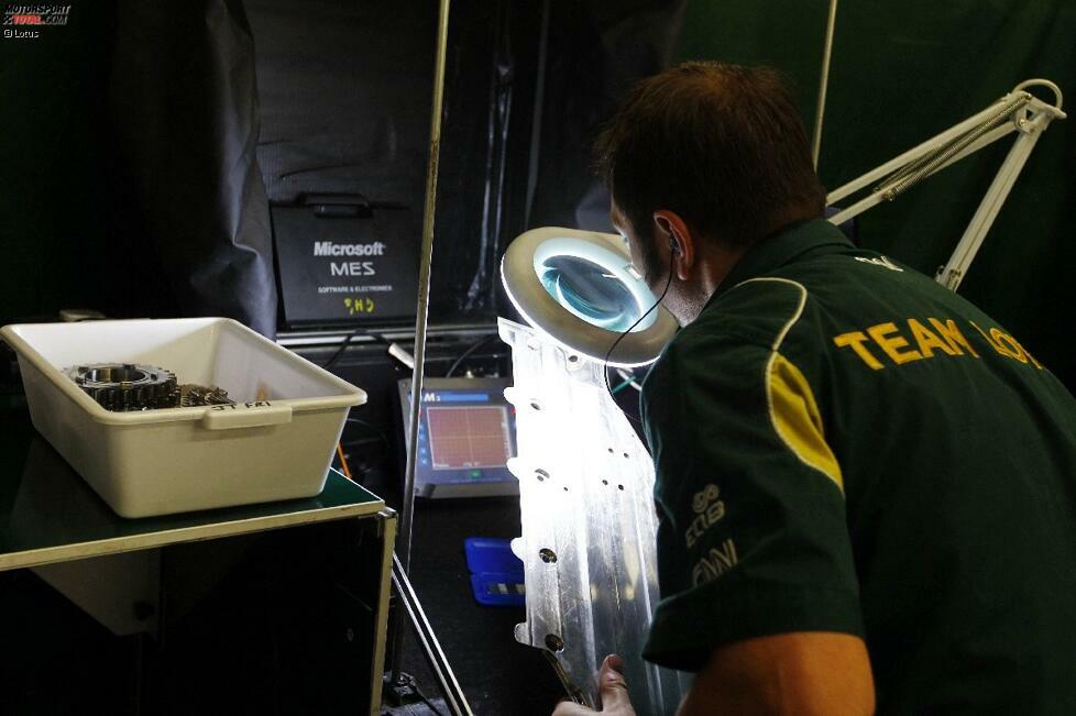 Hinter den Kulissen des Lotus-Teams: Ein Mechaniker untersucht Teile auf feine Risse, die zu Materialbrüchen führen können.