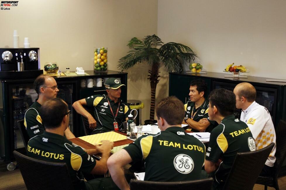 Technisches Meeting bei Lotus. Heikki Kovalainen erklärt seinen Ingenieuren im Hospitality-Häuschen, was sie noch besser machen können.