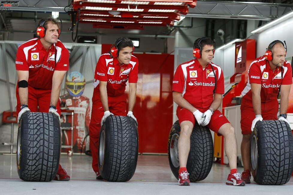 Ferrari-Mechaniker warten mit Pirelli-Reifen auf ihren Einsatz.