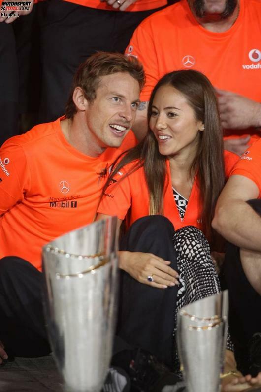 Jenson Button, im orangefarbenen McLaren-Sieger-T-Shirt und mit Freundin Jessica Michibata, gratuliert seinem Teamkollegen und feiert mit.
