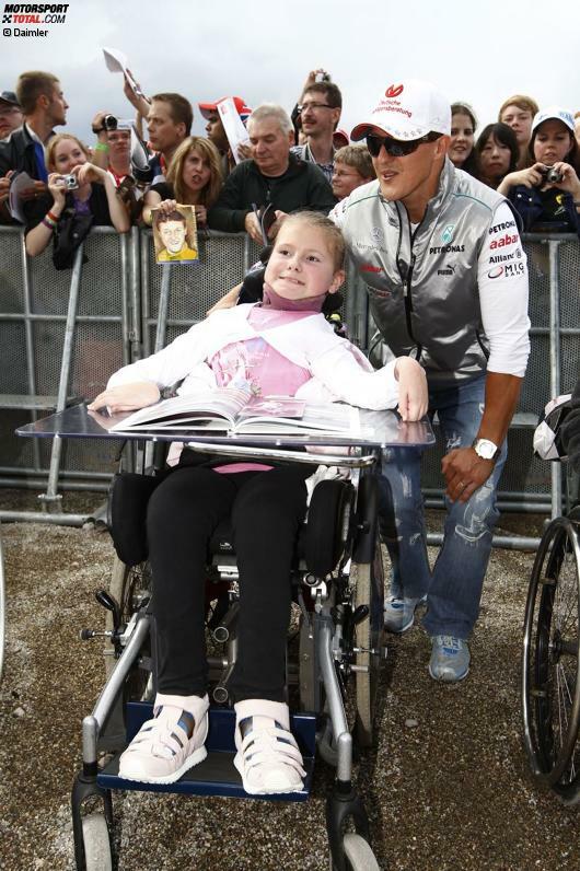 Ein Herz für Kinder: Michael Schumacher beschert diesem Fan im Vorfeld des Rennwochenendes eine unvergessliche Begegnung.
