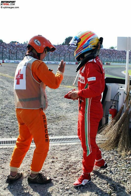 Fernando Alonso versteht die Welt nicht mehr: Zweite Nullnummer der Saison - und wieder von einem Lotus abgeschossen! Was ihm der japanische Streckenposten zu erklären versucht, ist dem Ferrari-Piloten in jenem Moment wahrscheinlich ziemlich egal.