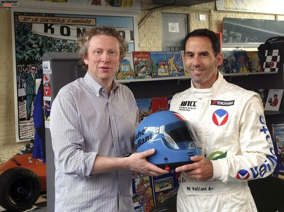 Philippe Graton, der Sohn des Michel-Vaillant-Erfinders Jean Graton, überreicht Alain Menu das letzte Stück der Ausrüstung: den Helm des Comic-Rennfahrers. Damit ist die Verwandlung von Alain Menu in Michel Vaillant komplett!