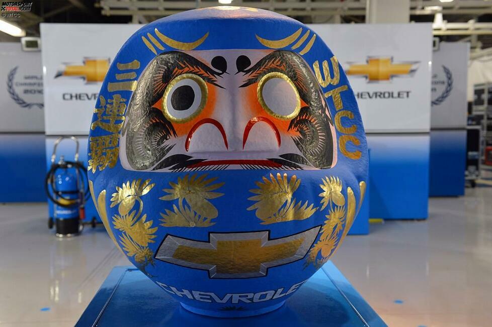 Ein original japanischer Daruma für das Chevrolet-Werksteam. Und der Glücksbringer bringt tatsächlich Glück. Vor allem aber Erfolg: In Suzuka macht Chevrolet den Sack zu und feiert zum dritten Mal in Folge den Gewinn der Hersteller-WM. Natürlich vorzeitig.