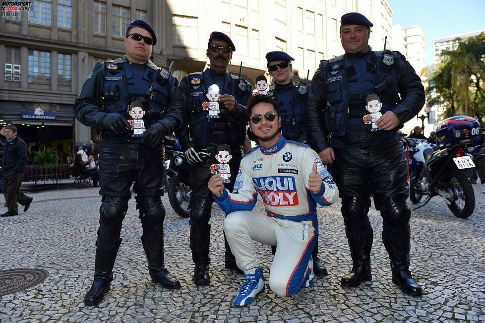 Neue Freunde finden: Charles Ng (Engstler-BMW) bringt seine Aufkleber, die ihn selbst als Comicfigur zeigen, auch in Brasilien an den Mann. Hier haben sich einige Polizisten spontan bereiterklärt, mit dem Rennfahrer zu posieren.