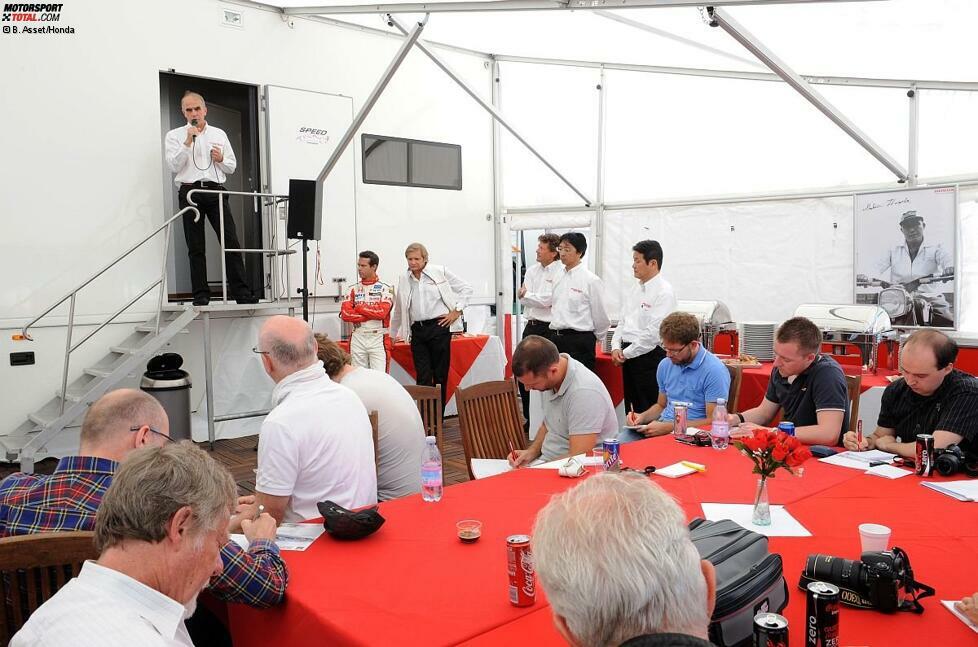 11:30 Uhr. Honda-PR-Chef William de Braekeleer begrüßt die Journalisten am Slovakiaring. Er erläutert das Tagesprogramm und erklärt Hintergründe zum WTCC-Einstieg der japanischen Marke. De Braekeleer stellt auch gleich die wichtigsten Personen des Rennprojekts vor, die sich unterhalb der Treppe versammelt haben. Die schreibende Zunft macht ihrem Beruf derweil alle Ehre und notiert fleißig mit ...