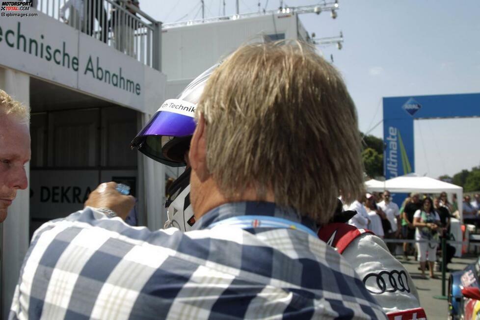 Zum Beispiel Mattias Ekström. Sie erinnern sich? Die Nummer mit der Wasserflasche am Norisring. Genau das ist das Bild dazu. Papa Ekström (vorn) hat das strittige Objekt in seiner linken Hand und holt gerade Schwung, um den Junior damit zu übergießen. Und das kostete Ekström jun. wenig später den Rennsieg am Dutzenteich...