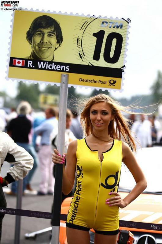 Zufall oder nicht? Gridgirl und Fahrer-Pappkamerad scheinen das gleiche Lächeln aufgesetzt zu haben...