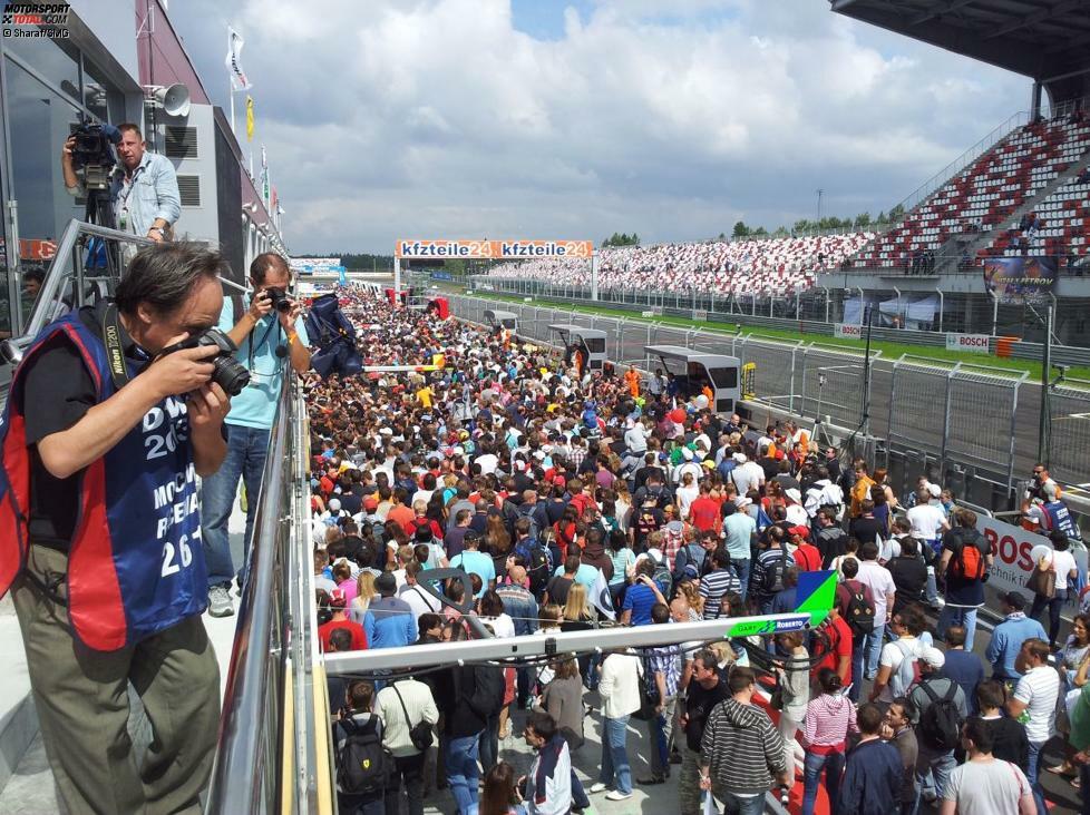 Großer Andrang: So viele Fans wie beim Pitwalk in Moskau schieben sich selten durch die Boxengasse. Übrigens tauchen an den DTM-Rennstrecken selten so viele Anhänger auf, die sich von Kopf bis Fuß in Teamkleidung geschmissen haben, wie in Russland.