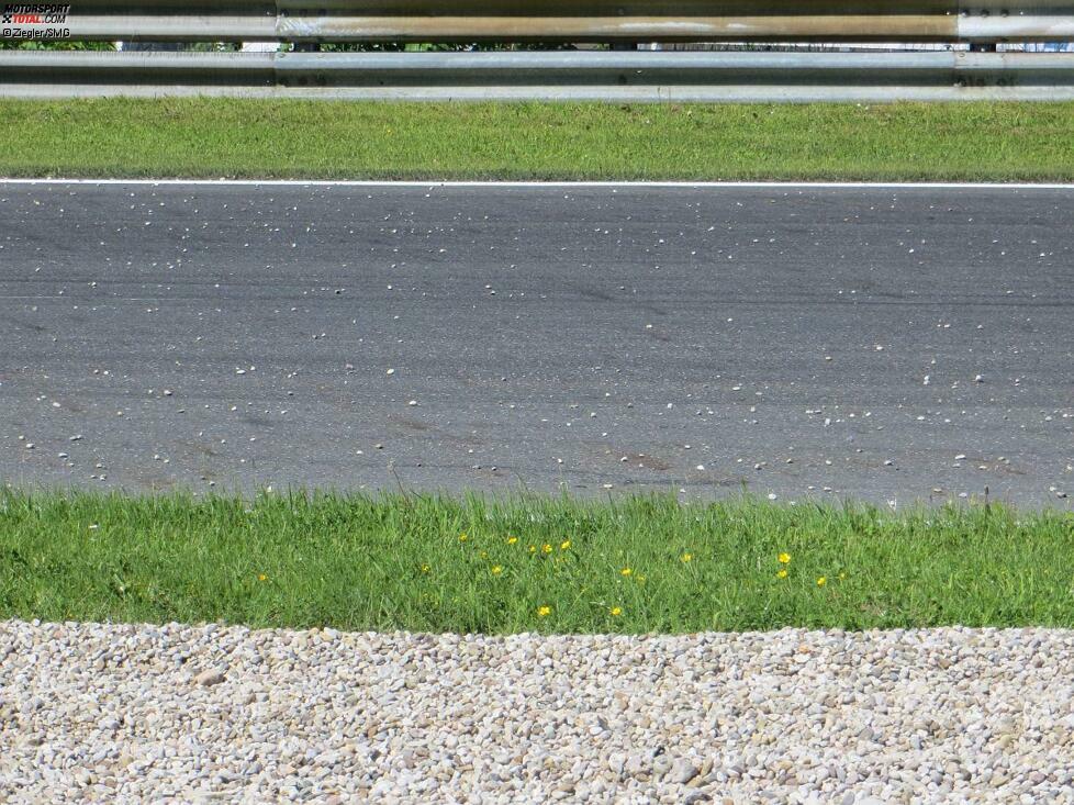 Noch ist das Training aber unterbrochen, denn die ganze Ideallinie ist voller Kieselsteine. Die hat der Fahrer bei seinem unfreiwilligen Ausflug auf die Fahrbahn geworfen.