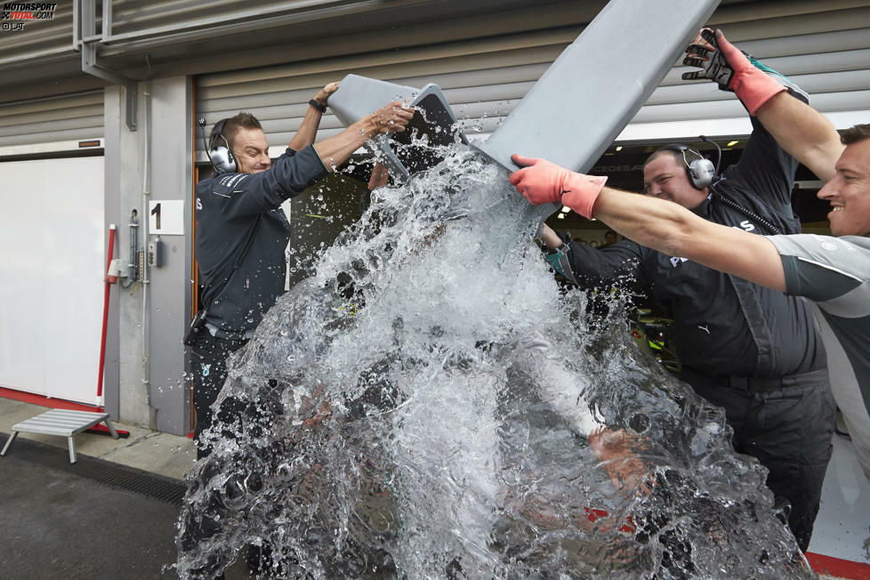 Lewis Hamilton ganz cool: Steigt nach dem Training wortlos aus dem Auto, macht ein paar Schritte aus der Garage raus, lässt sich von zwei Plastiktonnen voller Eiswasser übergießen und haut wieder ab.