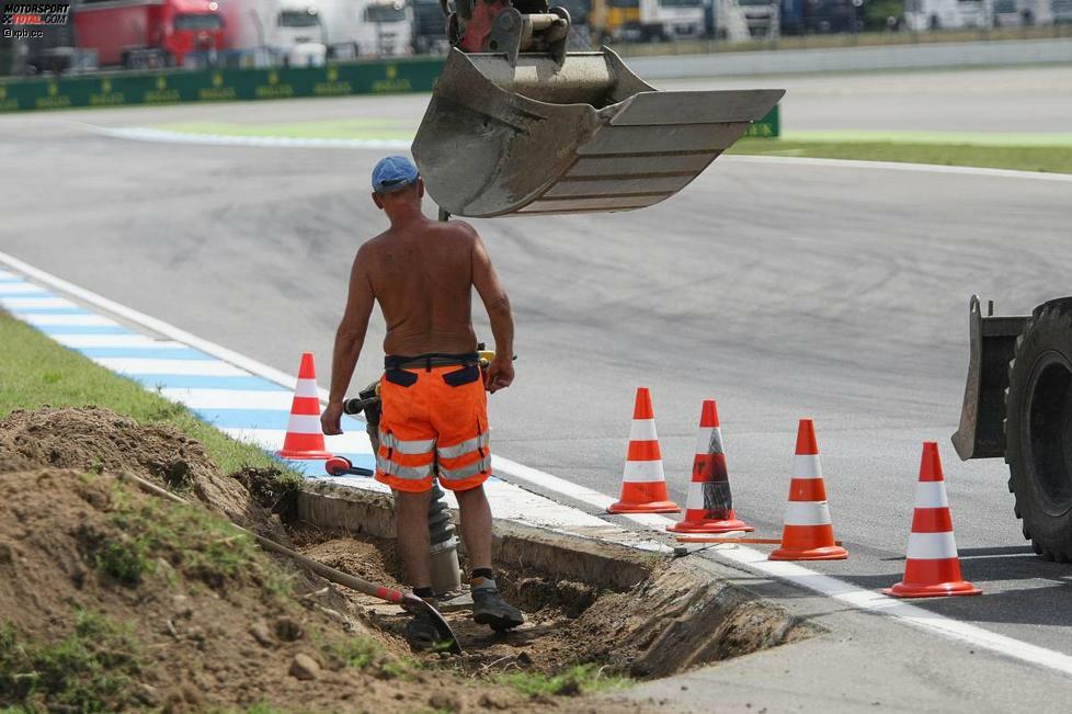 Genau wie dieser junge Mann, der die Rennstrecke auf Vordermann bringt. Warum hier so kurz vor Trainingsbeginn noch einmal aufgegraben wird, entzieht sich aber unserer Kenntnis.