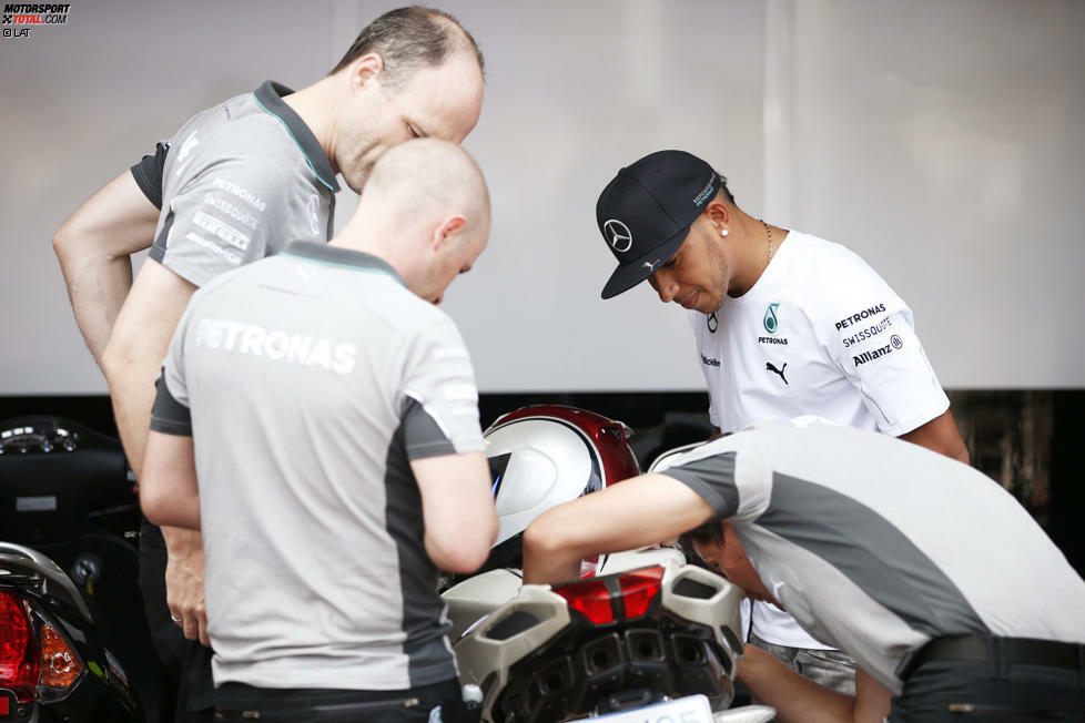 ... während Lewis Hamilton mit seinem neuen Motorrad daher rauscht. Das lässt er natürlich gleich mal von den Mercedes-Mechanikern begutachten. Vielleicht kann man ja noch ein paar PS mehr rauskitzeln!