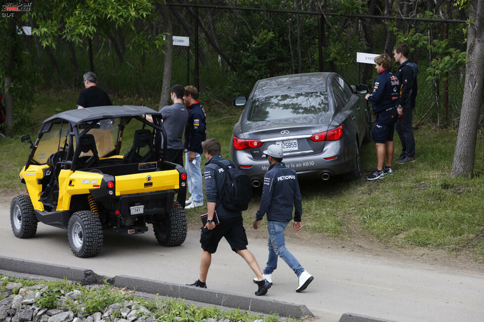 Besonders glamourös geht es auf dem Parkplatz der Akteure jedenfalls nicht zu. Während Sebastian Vettel (Red Bull) neben seinem Auto gerade noch einen Autogramm-Wunsch erfüllt, trottet Lewis Hamilton (Mercedes) im Vordergrund vorbei. Auf einer ganz normalen Wiese, über die sonst Murmeltiere krabbeln...