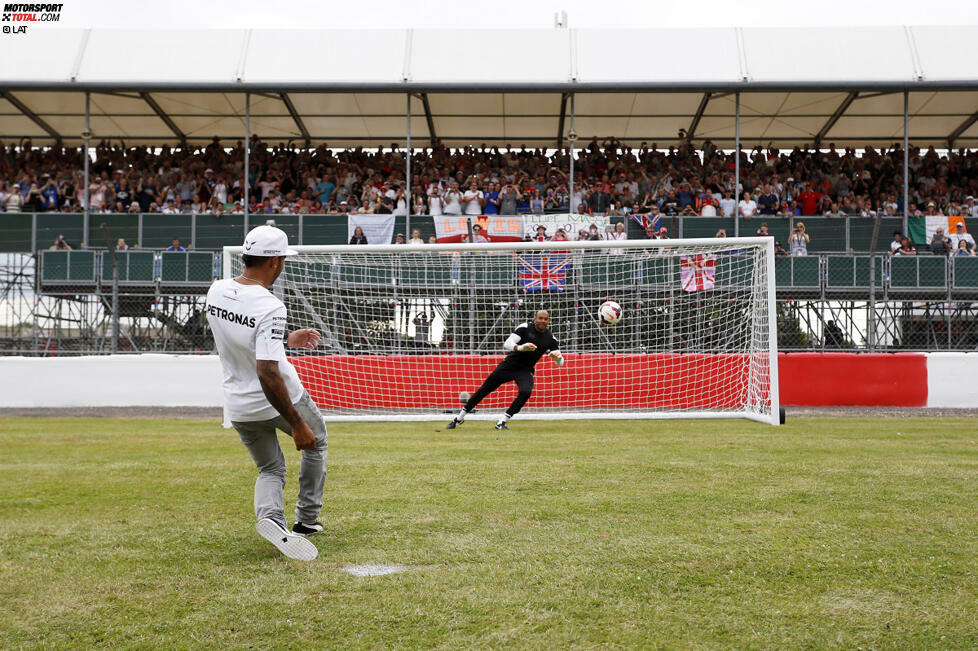 Lewis Hamilton tritt stilsicher an und versenkt die Kugel im Netz, wenn auch nicht bei all seinen Versuchen. Organisiert wird der kleine Kick übrigens vom britischen Fernsehen - sehr zur Freude der Fans, die schon vor dem ersten Training enthusiastischer jubeln als auf jeder anderen Rennstrecke.