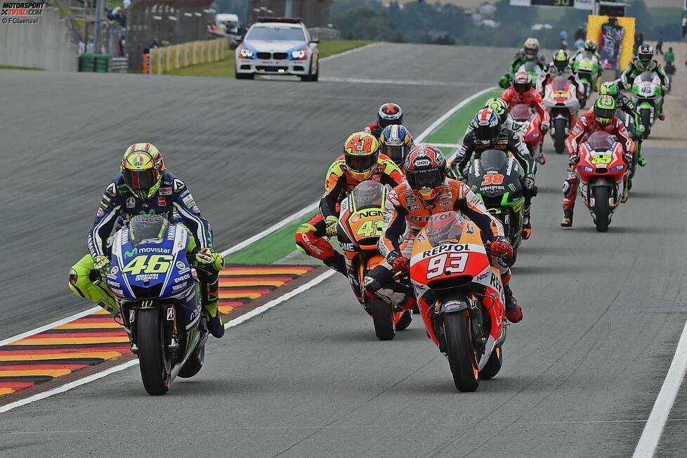 Insgesamt 14 Piloten biegen vor dem Start in die Boxengasse und tauschen ihre Motorräder. Am Ende der Boxengasse kommt es zu einem großen Durcheinander.