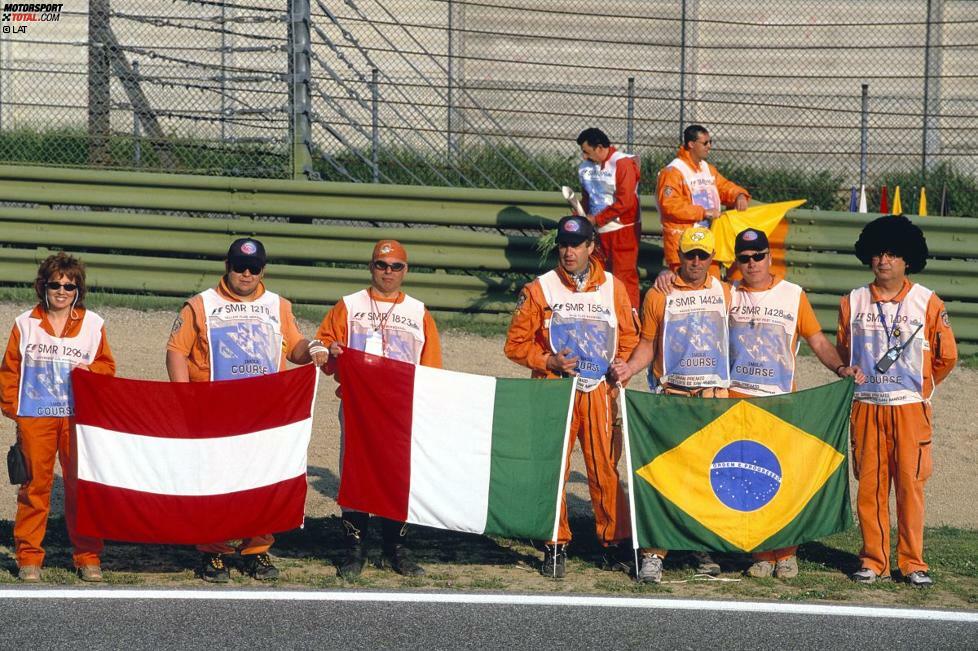 Imola 2004: Als sich das schwarze Wochenende zum zehnten Mal jährt, gedenken die Streckenposten den viel zu früh von der Welt gegangenen Piloten Roland Ratzenberger und Ayrton Senna.