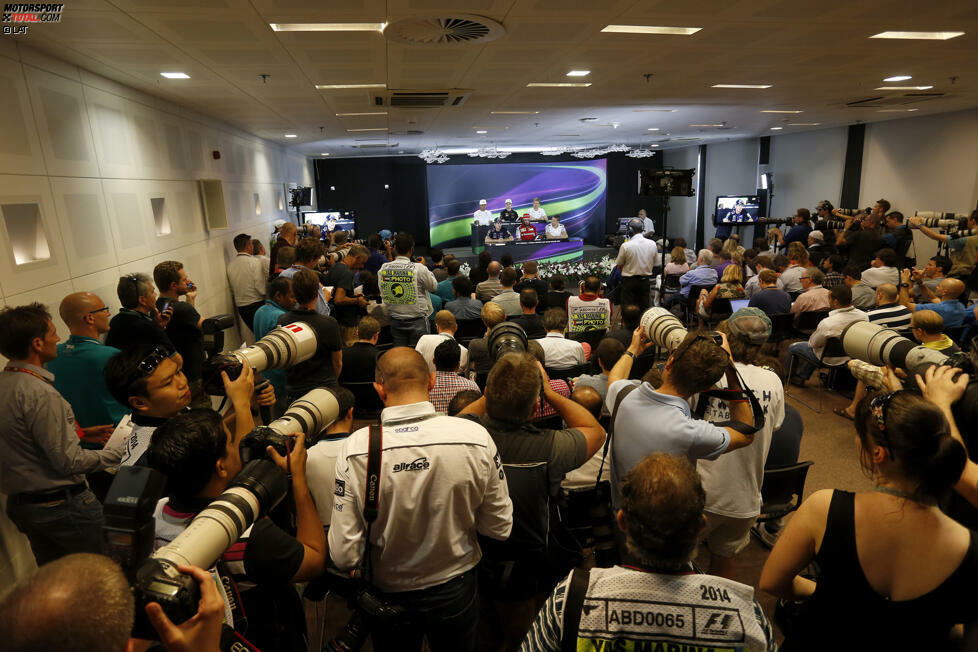 Weil am Donnerstag a) der Wechsel von Sebastian Vettel zu Ferrari endlich bekannt gegeben wird und die beiden Titelrivalen Lewis Hamilton und Nico Rosberg in der FIA-Pressekonferenz sitzen, ist der PK-Saal zum Bersten voll.