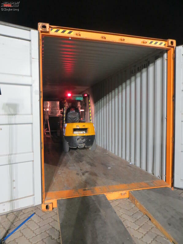 Mit dem Gapelstapler werden schwere Kisten direkt in den Container gefahren. Die Holzrampen davor helfen dabei - sie sind eine Maßanfertigung von DHL, um das Einladen zu erleichtern.