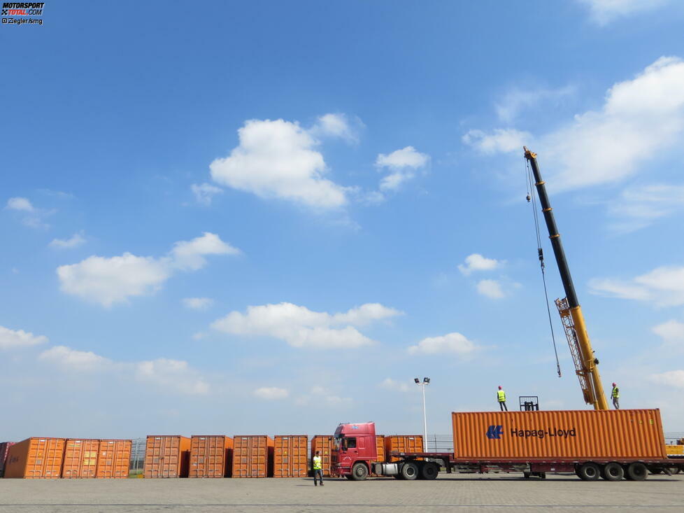 Der Kranwagen muss immer wieder seinen Standplatz wechseln, damit er die Container der Reihe nach absetzen kann.