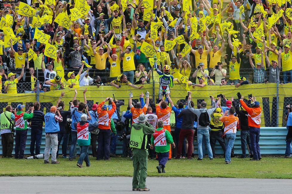 Rossi bleibt vorne und fährt als Erster über die Ziellinie. Die Emotionen sind groß. 97.000 Fans feiern den Superstar.