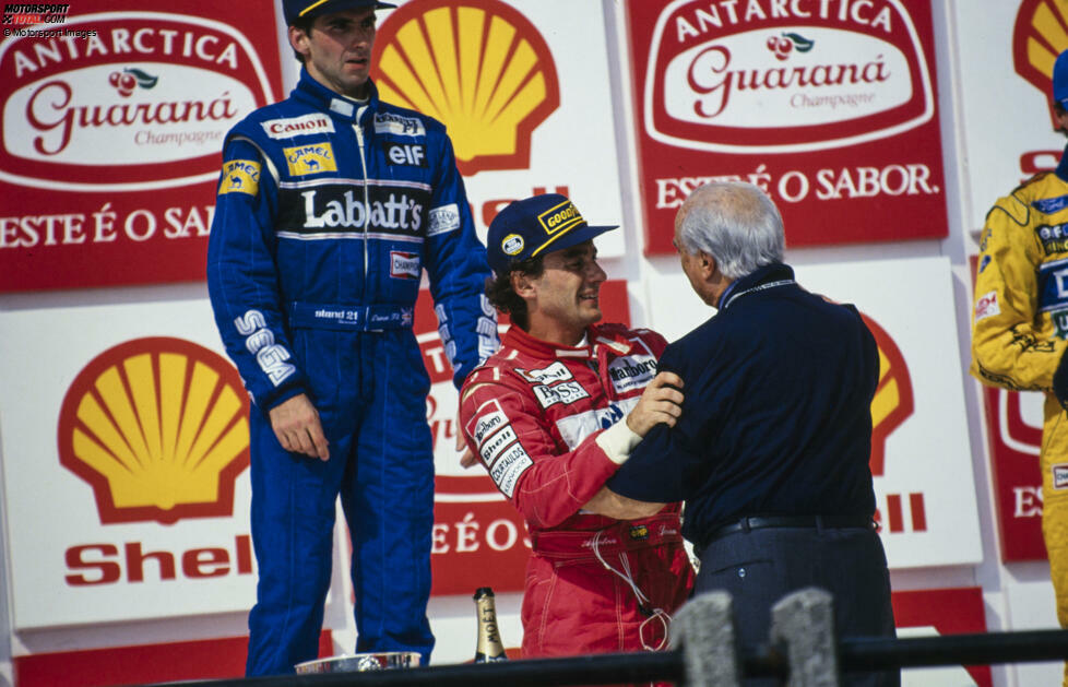 Umarmung zweier Formel-1-Legenden. 1993 kommt es beim Grand Prix von Brasilien zu einem emotionalen Moment, als Juan Manuel Fangio Ayrton Senna den Siegerpokal überreicht.
