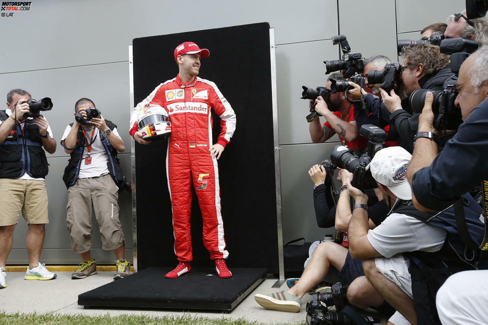 Aufgeregt: Mit dem roten Ferrari-Overall geht für Sebastian Vettel ein Lebenstraum in Erfüllung. Stolz präsentiert er sich beim traditionellen Saisonauftakt-Fotoshooting.