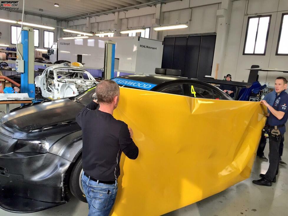 Gelb ist die neue Hauptfarbe von Tom Coronel, gelb wird auch sein Auto. Und das geht so: Eine große Folie wird herangetragen und am Auto angebracht.