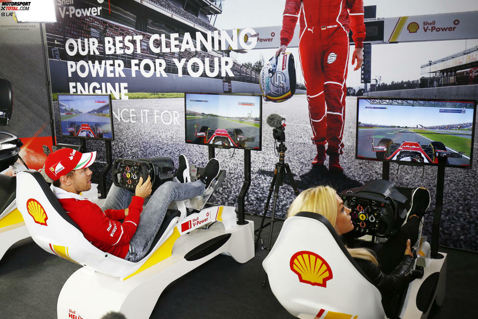 Nicht ganz die Rennstrecke, aber nahe dran: Sebastian Vettel misst sich im Simulator des Mineralölpartners der Scuderia Ferrari mit Fans. In Silverstone wird auch abseits der Strecke einiges geboten.