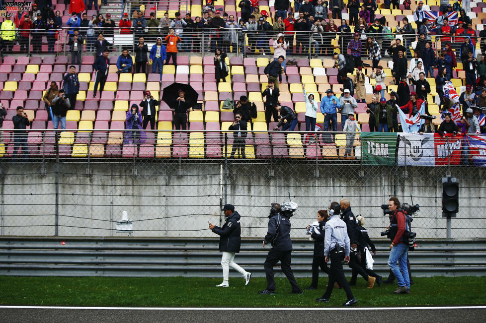 Der Freitag fällt ins Wasser: 22 Minuten Netto-Fahrzeit am Morgen, Training gestrichen am Nachmittag - weil der Rettungshubschrauber in einer Mischung aus Smog und Nebel nicht starten kann. Highlight des Tages also, wie Hamilton Kappen an die Fans verteilt - und dabei gefilmt wird, wie er mit seinem Handy filmt ...