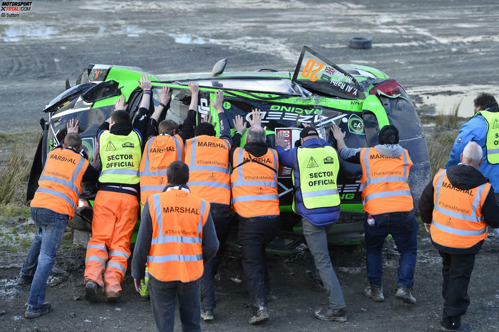 Mit vollen Einsatz drehen die Streckenposten das Wrack wieder auf die Räder.