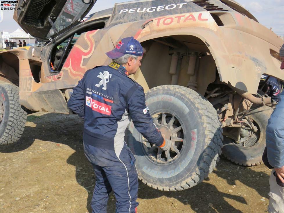 Bei einer Marathon-Etappe sind die Fahrer auf sich alleine gestellt und müssen Wartungen und Reparaturen selbstständig durchführen. Carlos Sainz beginnt schon mal mit dem Reifenwechsel.