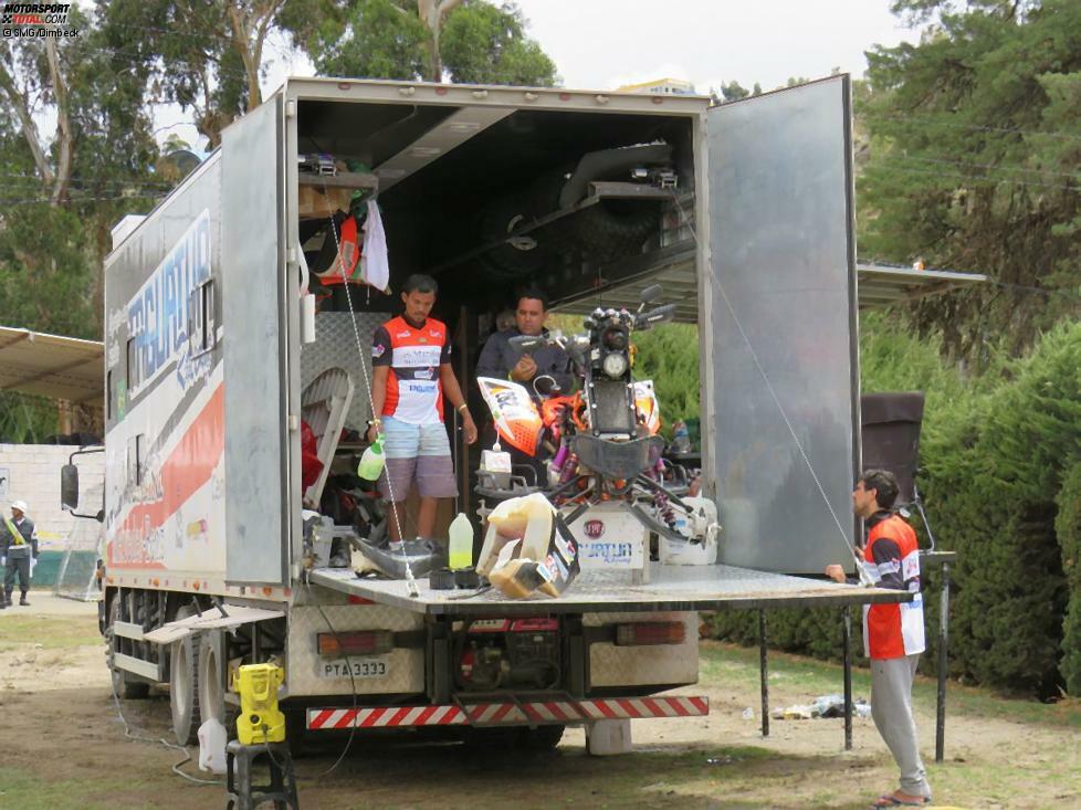 Ein Quad-Fahrer funktioniert einen LKW als Garage um. Improvisation ist bei der Rallye Dakar das A und O.