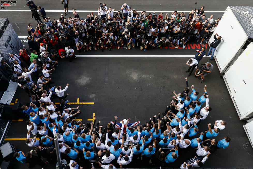 ... mit dem Mercedes-Team, das sich bereits seine WM-Shirts übergezogen und vor den Fotografen Aufstellung bezogen hat