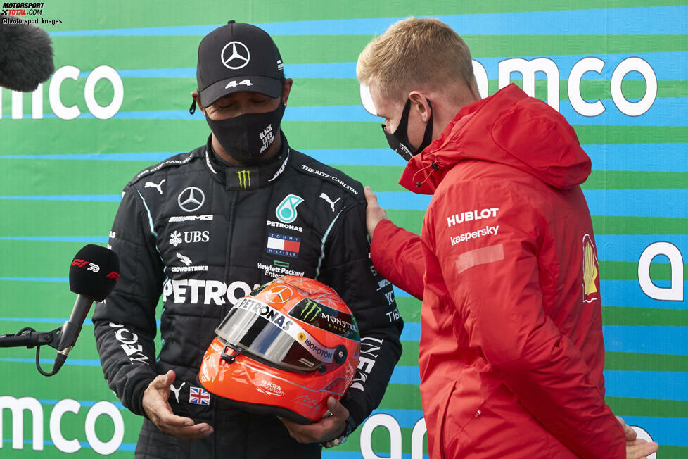 Nachdem Lewis Hamilton am Nürburgring mit seinem 91. Sieg den Rekord von Michael Schumacher eingestellt hat, überreicht Mick Schumacher einen Helm seines Vaters an Hamilton.