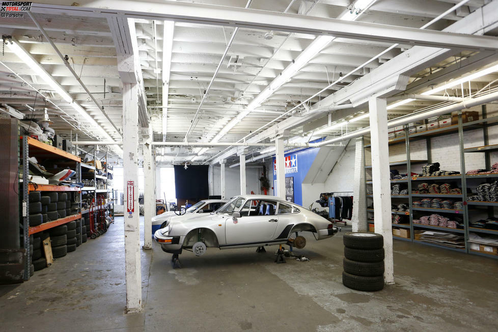 In der Werkstatt wartet unter anderem ein 911 Turbo auf die weitere Restauration. Viele Bauteile liegen in Regalen bereit.