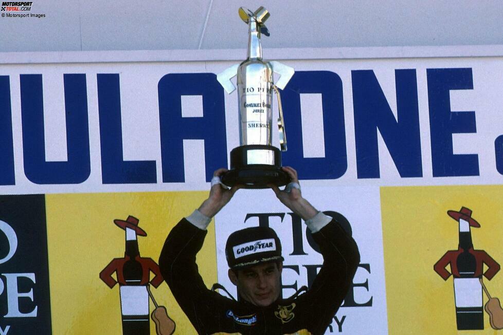Jerez 1986: Ayrton Senna reckt den besonderen Siegerpokal, der die Form einer Sherry-Flasche hat. Für das Getränk ist Jerez de la Frontera berühmt - und nutzt den Grand Prix als Werbemaßnahme. Sponsor Tio Pepe setzt dem Flaschen-Pokal einen Hut auf und stellt sogar eine Miniatur-Gitarre dazu!
