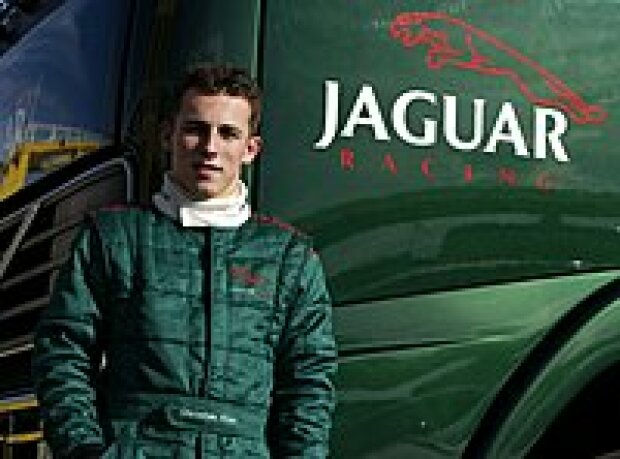 Titel-Bild zur News: Christian Klien vor einem Renntransporter des Jaguar-Teams